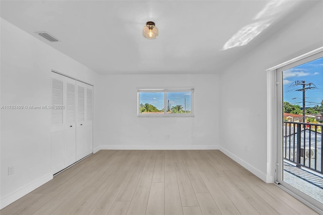 unfurnished bedroom featuring visible vents, light wood finished floors, baseboards, and access to outside