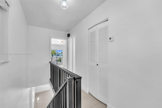 hallway featuring baseboards and an upstairs landing