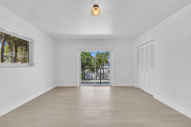 empty room with light wood finished floors and baseboards