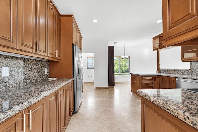 11201 SW 1st St, Plantation, FL 33325 - kitchen with light stone counters, decorative backsplash, a chandelier, brown cabinetry, and appliances with stainless steel finishes