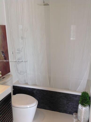 bathroom featuring shower / bath combo, vanity, and toilet