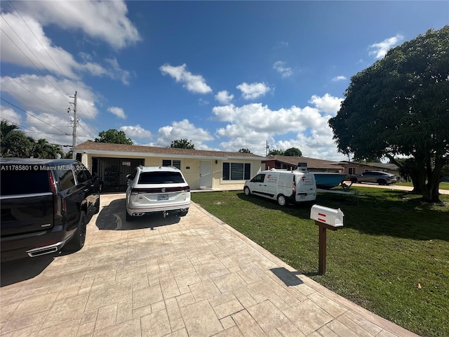 view of front of home with an attached garage, driveway, and a front yard