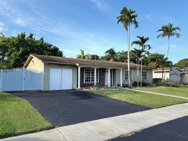 12021 SW 119th St, Miami, FL 33186 - ranch-style home with an attached garage, asphalt driveway, a gate, and stucco siding