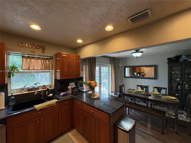 12021 SW 119th St, Miami, FL 33186 - kitchen with a peninsula, recessed lighting, backsplash, brown cabinetry, and light wood finished floors