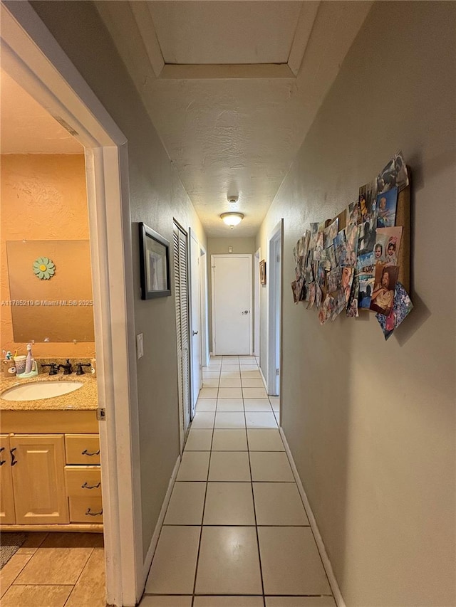 12021 SW 119th St, Miami, FL 33186 - corridor featuring light tile patterned floors and a sink