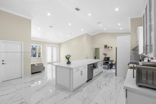 kitchen with a center island, ornamental molding, visible vents, and white cabinets