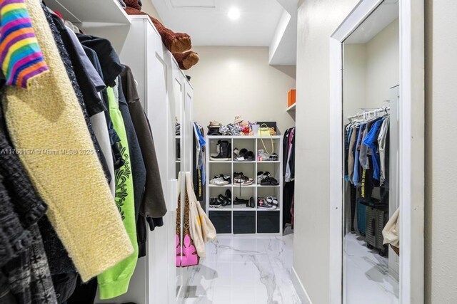 walk in closet with marble finish floor