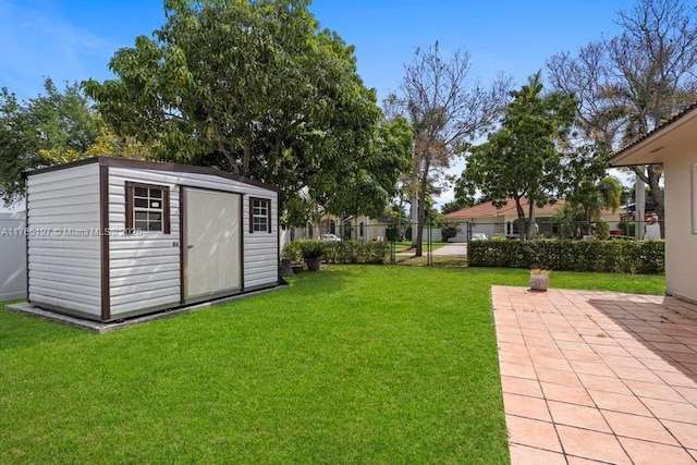 view of yard featuring fence, a storage unit, an outdoor structure, and a patio
