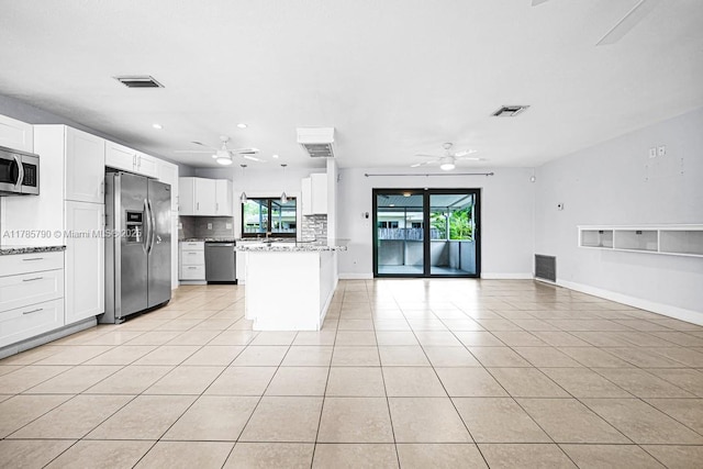 8451 NW 10th St, Pembroke Pines, FL 33024 - kitchen featuring stainless steel appliances, a ceiling fan, open floor plan, backsplash, and light tile patterned floors