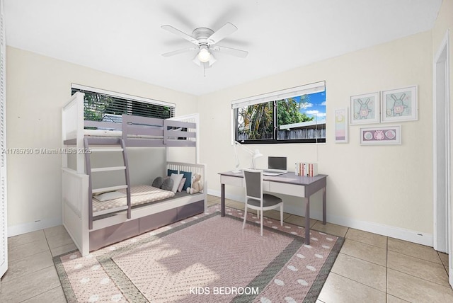 tiled bedroom featuring baseboards, multiple windows, and a ceiling fan