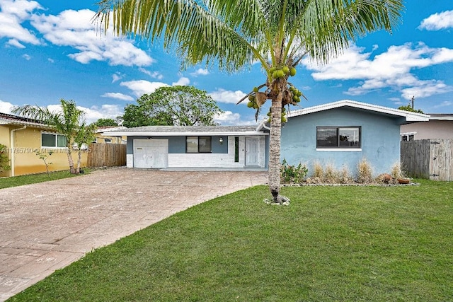 ranch-style home featuring fence, a garage, stucco siding, a front lawn, and decorative driveway