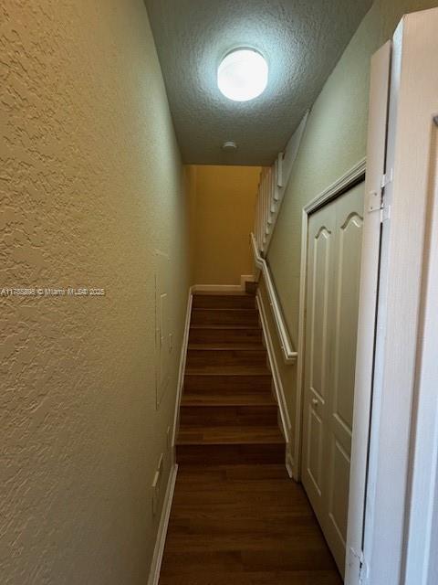 1017 Shoma Dr Unit 462, Royal Palm Beach, FL 33414 - stairway featuring a textured wall, baseboards, wood finished floors, and a textured ceiling