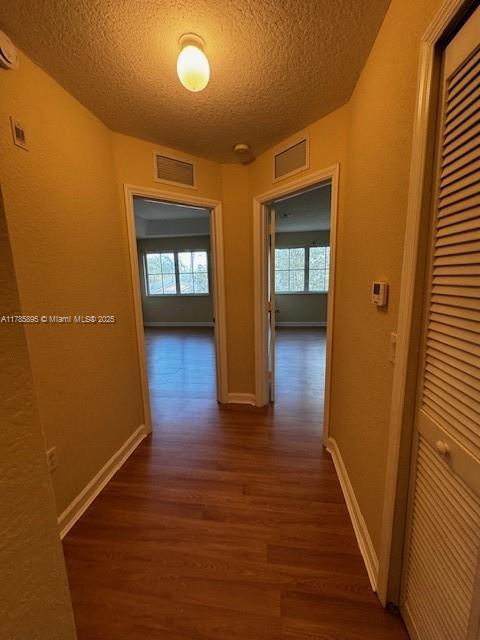 1017 Shoma Dr Unit 462, Royal Palm Beach, FL 33414 - corridor featuring dark wood finished floors, a wealth of natural light, a textured ceiling, and visible vents