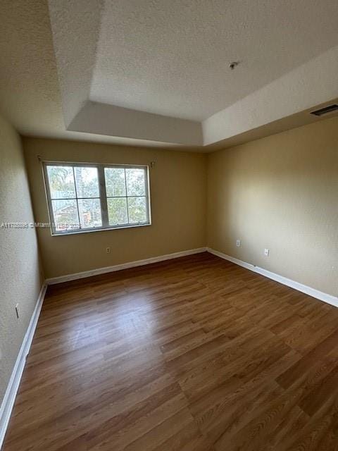 1017 Shoma Dr Unit 462, Royal Palm Beach, FL 33414 - unfurnished room featuring baseboards, wood finished floors, visible vents, and a textured ceiling