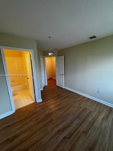 1017 Shoma Dr Unit 462, Royal Palm Beach, FL 33414 - unfurnished bedroom with baseboards, visible vents, and dark wood-type flooring