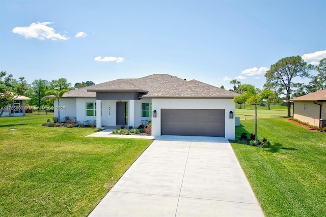 prairie-style home featuring an attached garage, a front lawn, driveway, and stucco siding