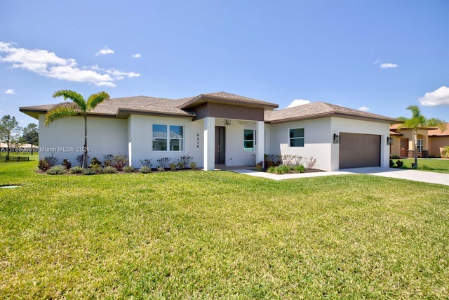 prairie-style home with an attached garage, a front lawn, stucco siding, and driveway