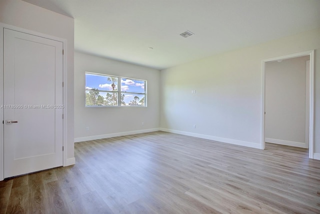 unfurnished bedroom with baseboards, wood finished floors, and visible vents