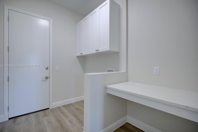 laundry room with light wood finished floors, baseboards, hookup for a washing machine, and cabinet space