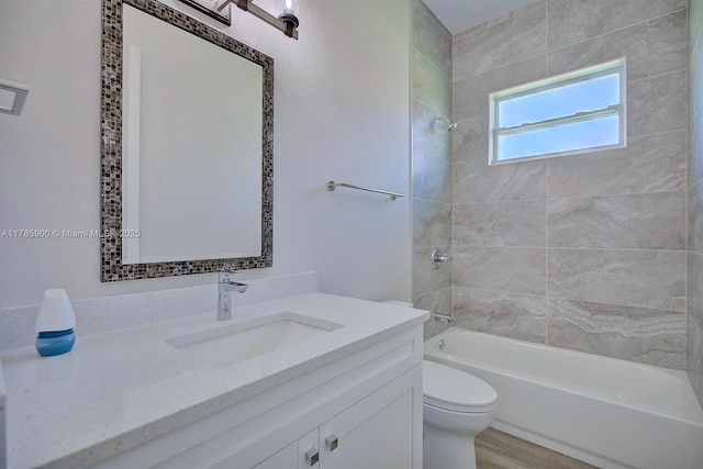 full bathroom with wood finished floors, washtub / shower combination, vanity, and toilet