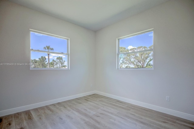 unfurnished room with baseboards and wood finished floors