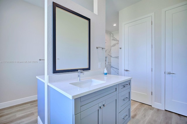 bathroom featuring baseboards, wood finished floors, and vanity