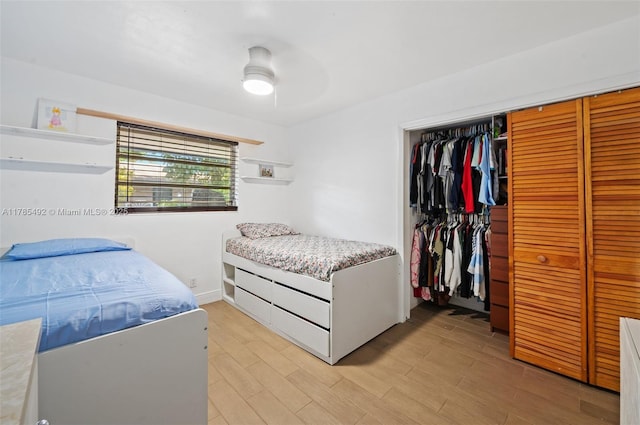 bedroom with light wood-style flooring, a closet, and ceiling fan
