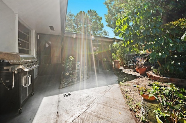 view of patio with fence, a carport, and a sunroom