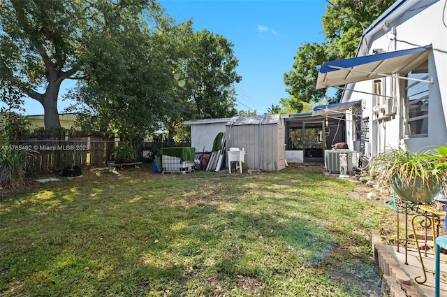 view of yard featuring central air condition unit, an outbuilding, and fence