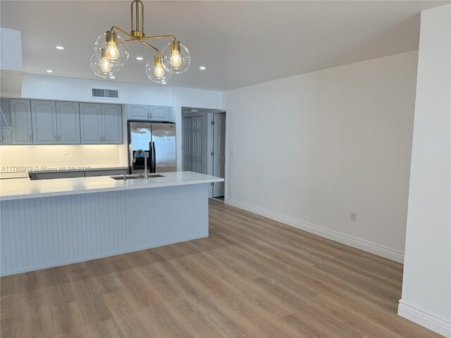 16528 Bridge End Rd, Miami Lakes, FL 33014 - kitchen with light wood-style floors, stainless steel refrigerator with ice dispenser, light countertops, recessed lighting, and a peninsula