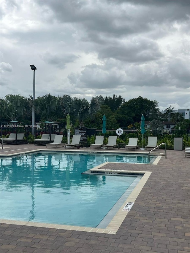 pool with fence and a patio area