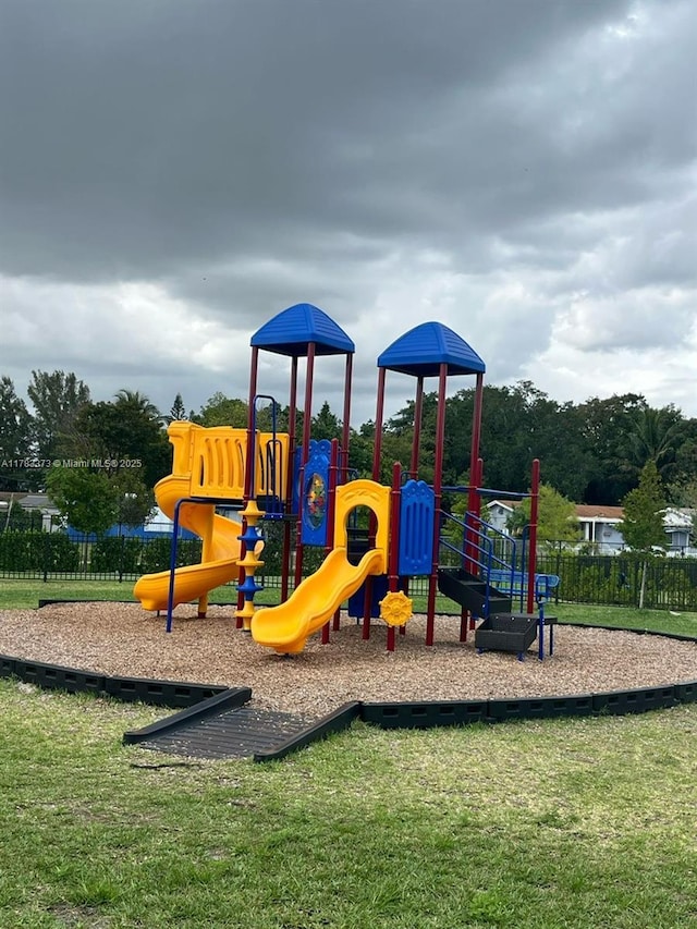 community play area featuring fence and a yard