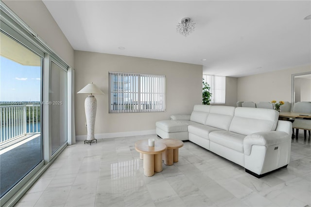 living area featuring marble finish floor and baseboards