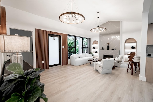 751 NE 80th St, Miami, FL 33138 - living room featuring a fireplace, wood finished floors, an inviting chandelier, and high vaulted ceiling