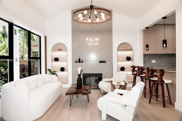 751 NE 80th St, Miami, FL 33138 - living room featuring a chandelier, light wood-style flooring, a high ceiling, and built in features