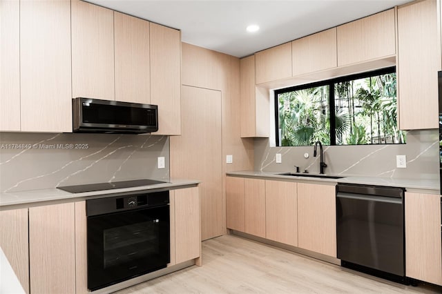 751 NE 80th St, Miami, FL 33138 - kitchen with black appliances, tasteful backsplash, a sink, and light countertops