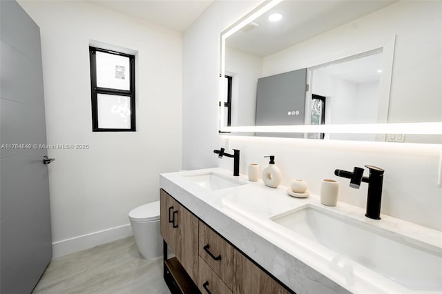 751 NE 80th St, Miami, FL 33138 - full bathroom featuring double vanity, toilet, baseboards, and a sink