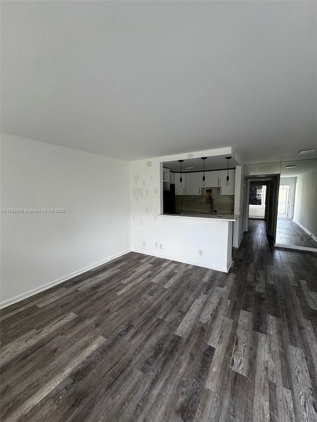 22 Suffolk A 22, Boca Raton, FL 33434 - unfurnished living room with baseboards and dark wood finished floors