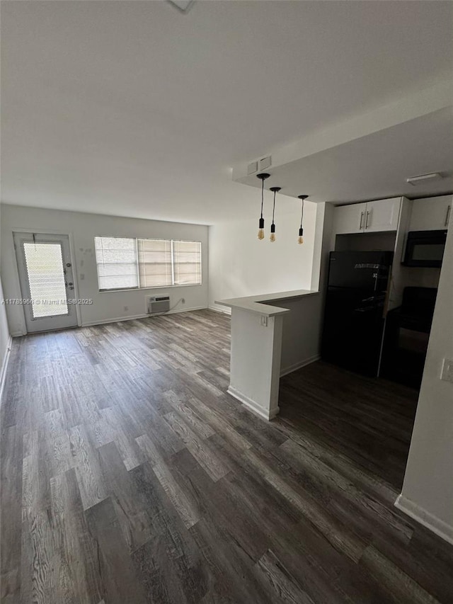 22 Suffolk A 22, Boca Raton, FL 33434 - kitchen featuring white cabinets, black appliances, open floor plan, dark wood finished floors, and a peninsula