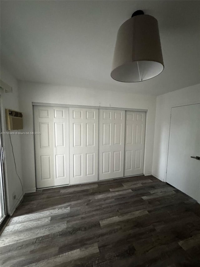 22 Suffolk A 22, Boca Raton, FL 33434 - unfurnished bedroom featuring wood finished floors, a wall mounted air conditioner, and a closet