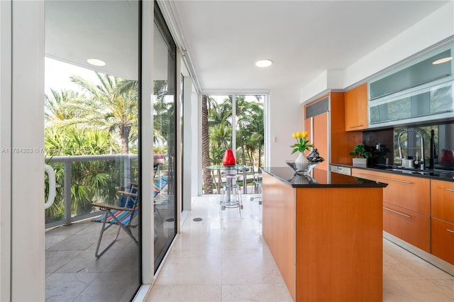 18911 Collins Ave Unit 405, Sunny Isles Beach, FL 33160 - kitchen with a kitchen island, a wall of windows, dark countertops, modern cabinets, and light tile patterned floors