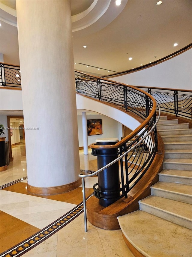 stairway featuring recessed lighting, a high ceiling, and baseboards