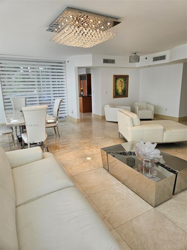 living room with visible vents, baseboards, and a notable chandelier