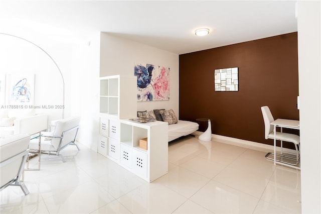 tiled bedroom featuring baseboards and an accent wall