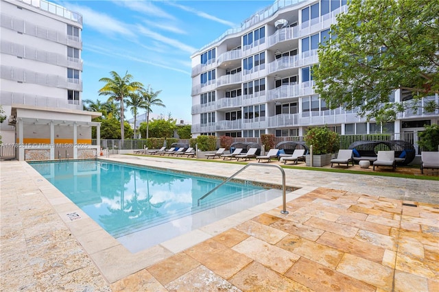 community pool with fence and a patio area