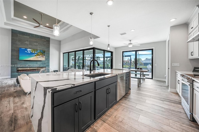 kitchen featuring a sink, ceiling fan, stainless steel appliances, baseboards, and visible vents