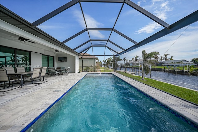 pool with a ceiling fan, a lanai, outdoor dining area, and a patio