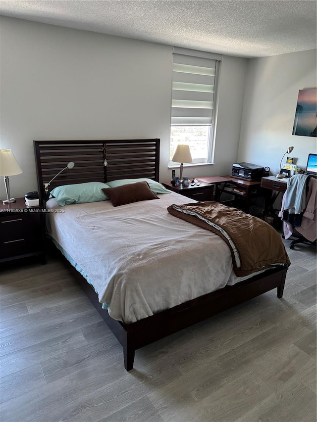bedroom with wood finished floors and a textured ceiling
