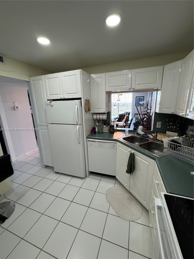 kitchen featuring light tile patterned flooring, white cabinetry, a sink, and white appliances