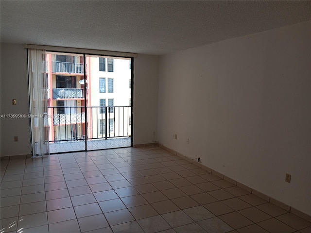9688 Fontainebleau Blvd Unit 401, Miami, FL 33172 - empty room featuring baseboards, light tile patterned floors, a textured ceiling, and expansive windows